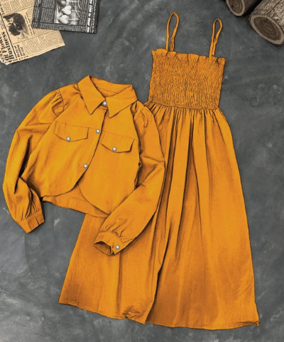 Mustard yellow smocked sundress with matching cropped jacket on gray background