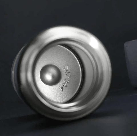 Close-up of stainless steel water bottle interior marked SUS304 on dark background