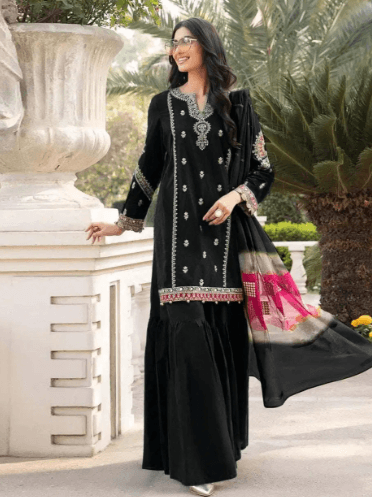 Woman in black embroidered ethnic suit with matching dupatta outdoors, traditional fashion