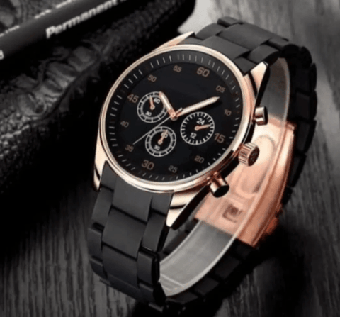 Black luxury chronograph wristwatch with gold accents on a dark wooden surface